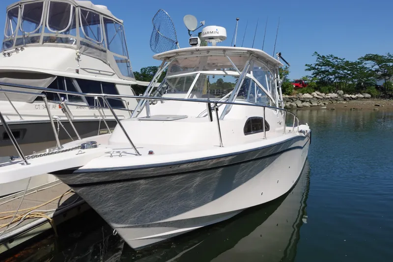  Yacht Photos Pics 2002 Grady-White Marlin 300 boat docked in a marina, clear blue sky.