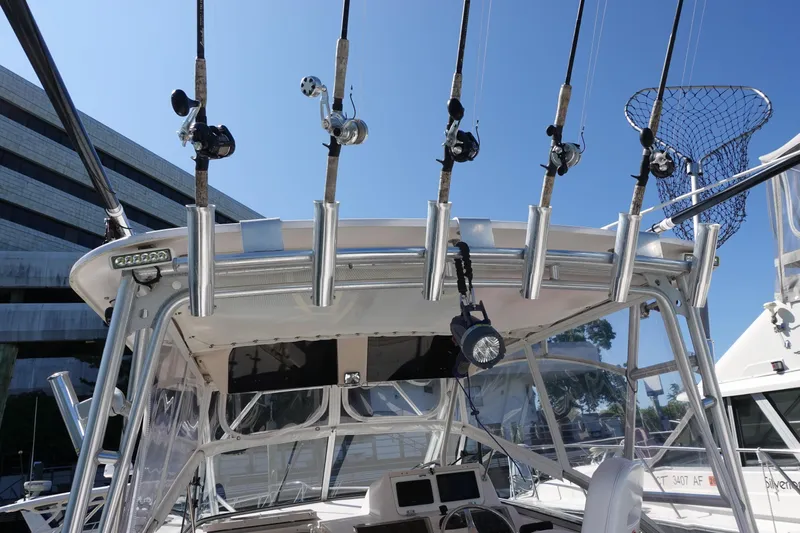  Yacht Photos Pics Fishing rods on a 2002 Grady White 300 Marlin boat, docked under clear blue sky.