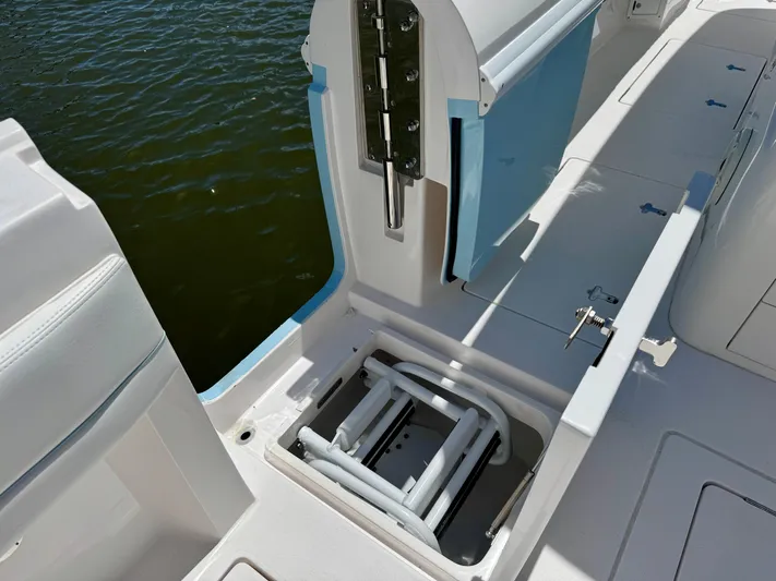  Yacht Photos Pics 2020 Intrepid 375 Nomad FE boat with open storage compartment near water.