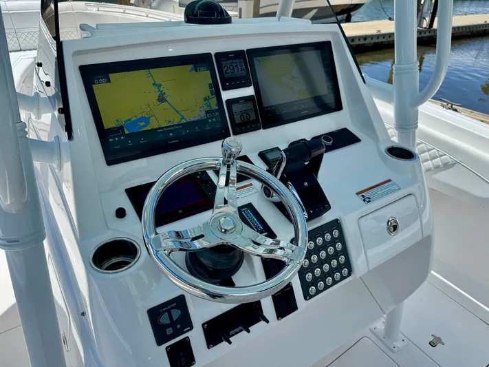  Yacht Photos Pics Control panel of 2020 Intrepid 375 Nomad FE boat with navigation screens and steering wheel.