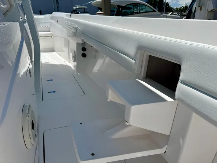  Yacht Photos Pics 2020 Intrepid 375 Nomad FE boat interior with white seating and storage compartments.