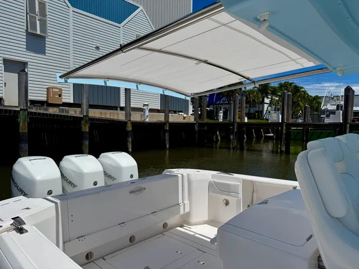  Yacht Photos Pics 2020 Intrepid 375 Nomad FE boat with canopy, docked near waterfront buildings.