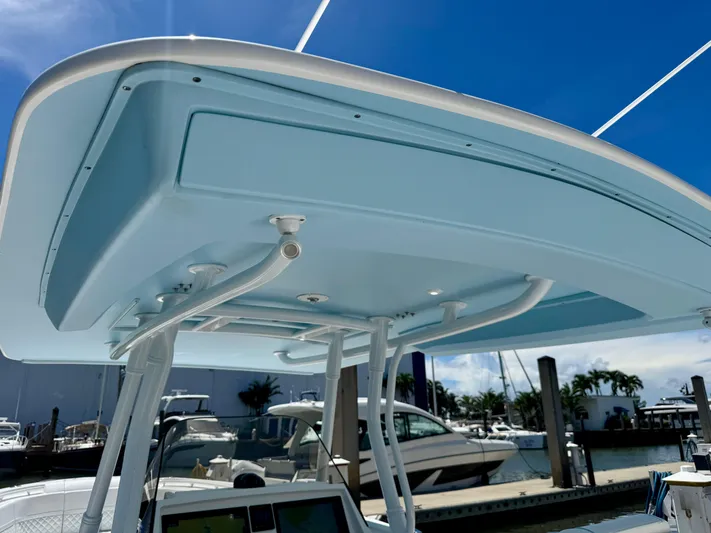  Yacht Photos Pics 2020 Intrepid 375 Nomad FE boat with sleek blue canopy and marina background.