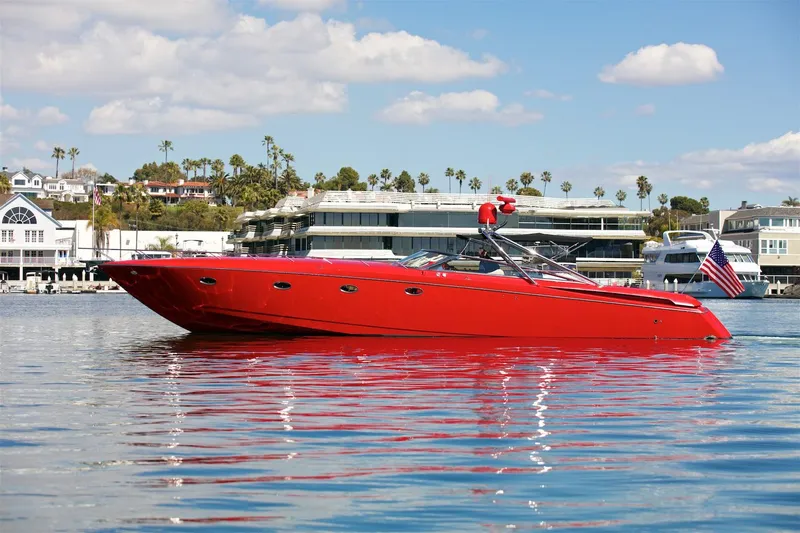  Yacht Photos Pics Red 2002 Hallett Express Cruiser on calm water with buildings in the background.