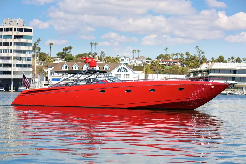  Yacht Photos Pics Red 2002 Hallett Express Cruiser on calm water with buildings in the background.