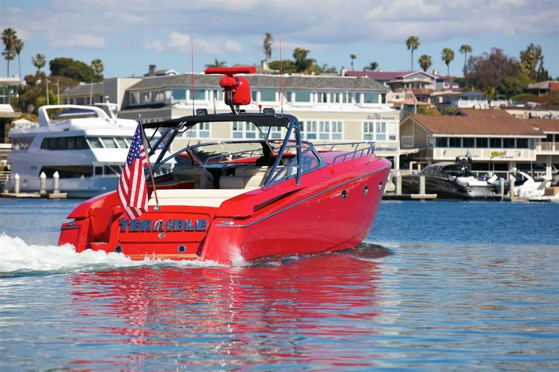  Yacht Photos Pics Red 2002 Hallett Express Cruiser boat on water, American flag, marina background.