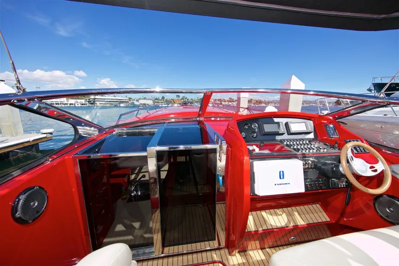  Yacht Photos Pics 2002 Hallett Express Cruiser cockpit with red interior, modern controls, and waterfront view.