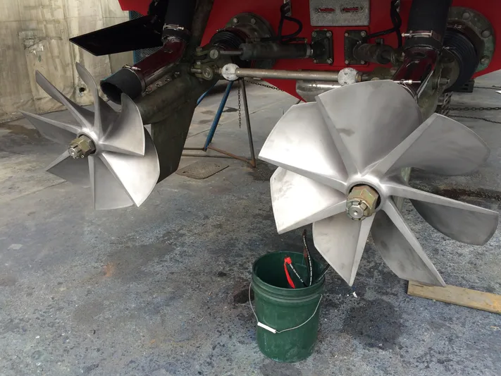  Yacht Photos Pics Propellers of a 2002 Hallett Express Cruiser boat, displayed in a maintenance area.
