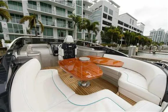  Yacht Photos Pics Luxurious 2014 Riva Rivarama Super 44 yacht with elegant seating and wooden table, docked near modern buildings.