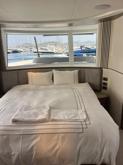  Yacht Photos Pics Luxurious bedroom in 2023 Princess X80 yacht with marina view through large windows.