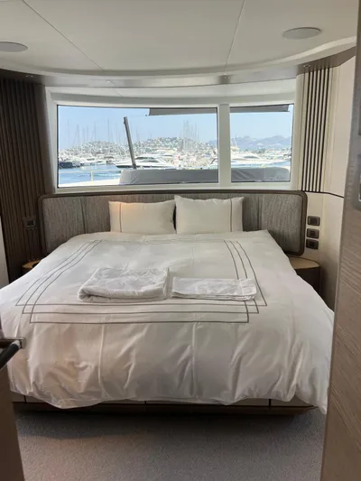 Yacht Photos Pics Luxurious bedroom on 2023 Princess X80 yacht with marina view through large windows.