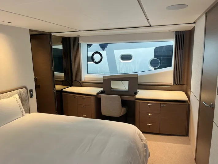  Yacht Photos Pics Luxurious 2023 Princess X80 yacht bedroom with elegant furnishings and large window view.