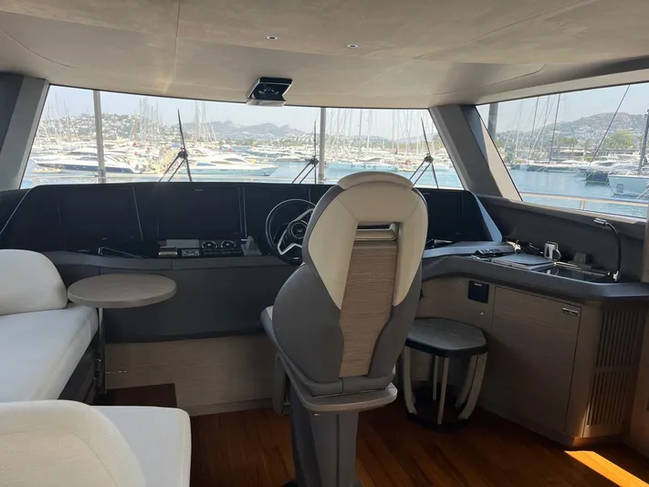  Yacht Photos Pics Luxurious interior of 2023 Princess X80 yacht with helm, seating, and marina view.