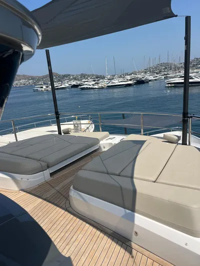  Yacht Photos Pics Luxurious 2023 Princess X80 yacht deck with sunbeds, overlooking a marina.