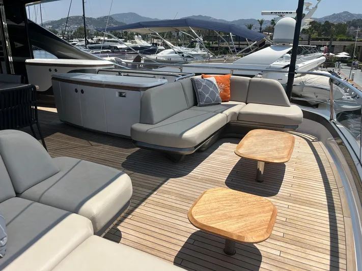  Yacht Photos Pics Luxurious 2023 Princess X80 yacht deck with elegant seating and wooden tables.