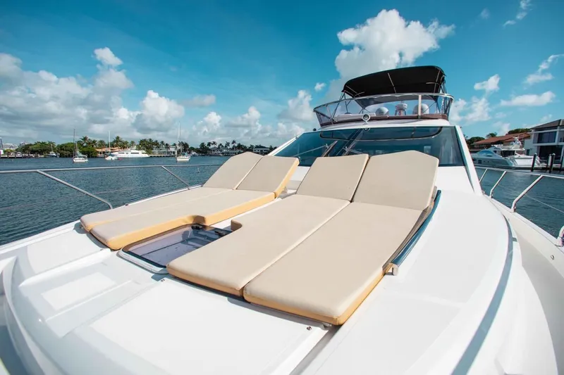  Yacht Photos Pics Luxurious 2015 Absolute 56 FLY yacht with sun loungers on deck, docked in a marina.