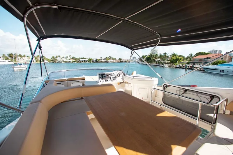  Yacht Photos Pics Flybridge view of 2015 Absolute 56 FLY yacht with seating and table, overlooking marina.