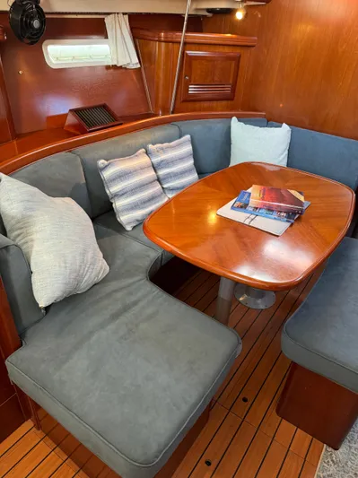 Interlude Yacht Photos Pics Interior of 2002 Beneteau 393 sailboat with cozy seating and wooden table.