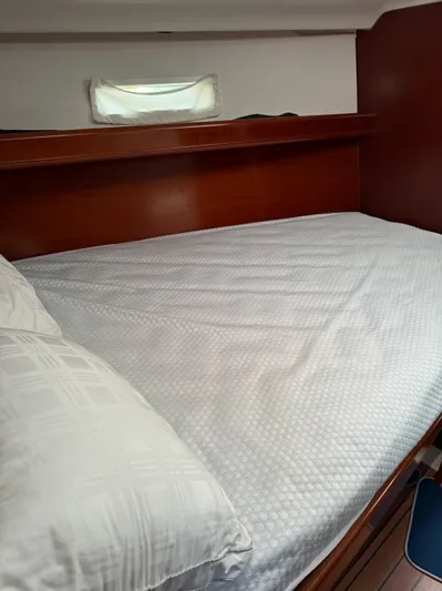 Interlude Yacht Photos Pics Cozy cabin interior of 2002 Beneteau 393 sailboat with wooden finish and comfortable bedding.