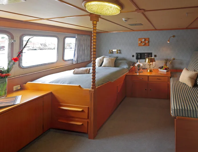 Sanssouci Star Yacht Photos Pics Luxurious cabin interior of 1982 Custom Displacement Twin Screw yacht with cozy bed and seating area.