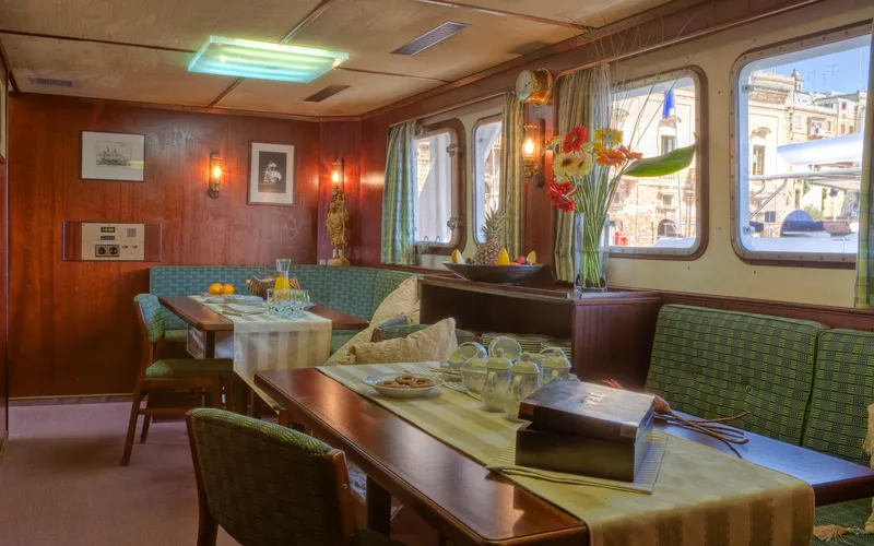 Sanssouci Star Yacht Photos Pics Vintage 1982 Custom Displacement Twin Screw yacht interior with dining area and large windows.