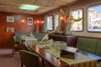 Vintage 1982 Custom Displacement Twin Screw yacht interior with dining area and large windows.