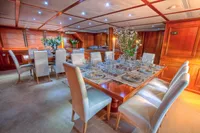 Luxurious yacht dining room with elegant table setting, Custom Displacement Twin Screw, 1982.