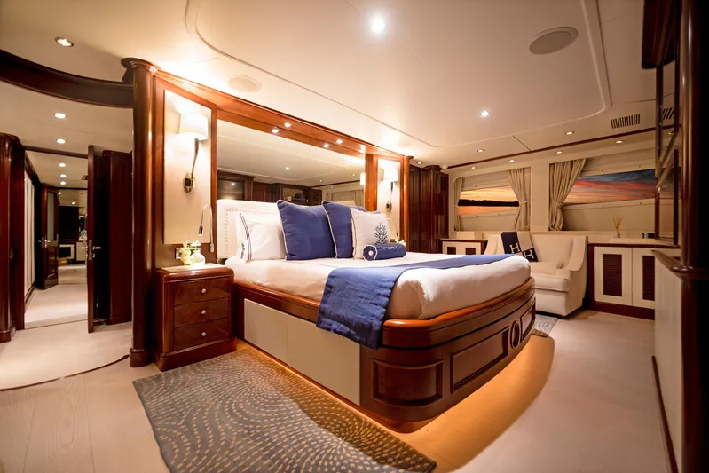 Fortis Benetti 115 Classic Yacht Photos Pics Luxurious bedroom interior of 2003 Benetti 115 Classic yacht with elegant wood finishes and ambient lighting.