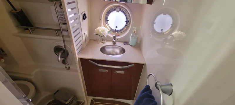  Yacht Photos Pics 2008 Sea Ray 350 Sundancer bathroom with sink, porthole, and storage cabinets.