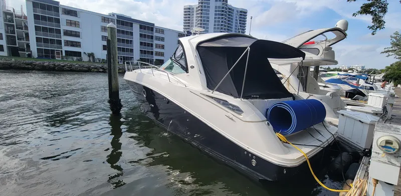  Yacht Photos Pics 2008 Sea Ray 350 Sundancer docked at a marina with modern buildings in the background.