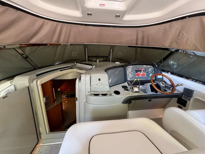 Knot Satisfied Yacht Photos Pics 2006 Sea Ray 38 Sundancer helm with wood-accented steering wheel and cabin entrance.