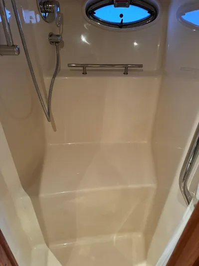 Knot Satisfied Yacht Photos Pics 2006 Sea Ray 38 Sundancer shower interior with chrome fixtures and porthole window.