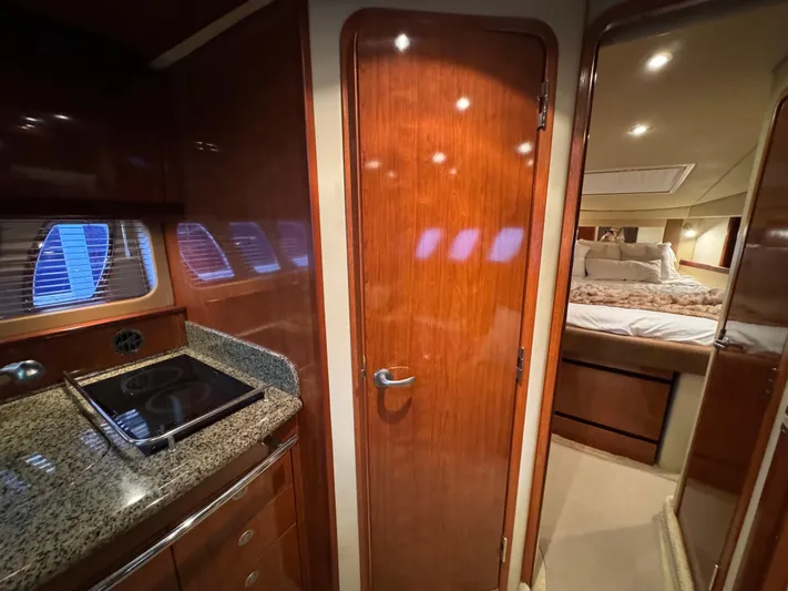 Knot Satisfied Yacht Photos Pics Interior of 2006 Sea Ray 38 Sundancer yacht with wood finishes and cozy bedroom.