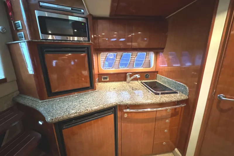 Knot Satisfied Yacht Photos Pics 2006 Sea Ray 38 Sundancer yacht kitchen with wood cabinets and granite countertops.