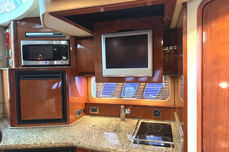 Knot Satisfied Yacht Photos Pics Interior of 2006 Sea Ray 38 Sundancer yacht with kitchen appliances and TV.