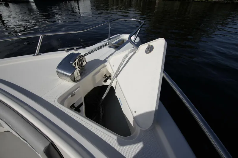  Yacht Photos Pics 2001 Pursuit 3070 Center Console boat anchor compartment with open hatch on calm water.