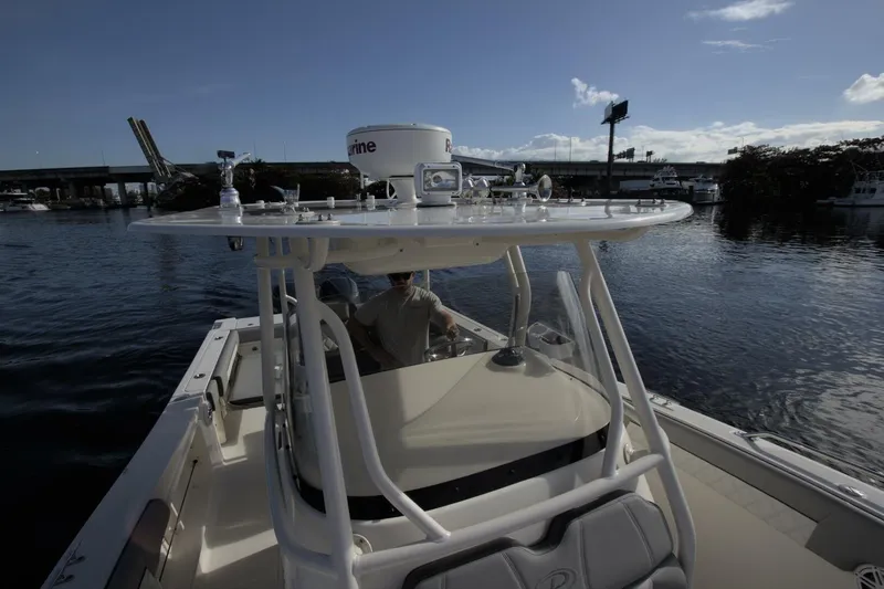  Yacht Photos Pics 2001 Pursuit 3070 Center Console boat on calm water near a bridge.