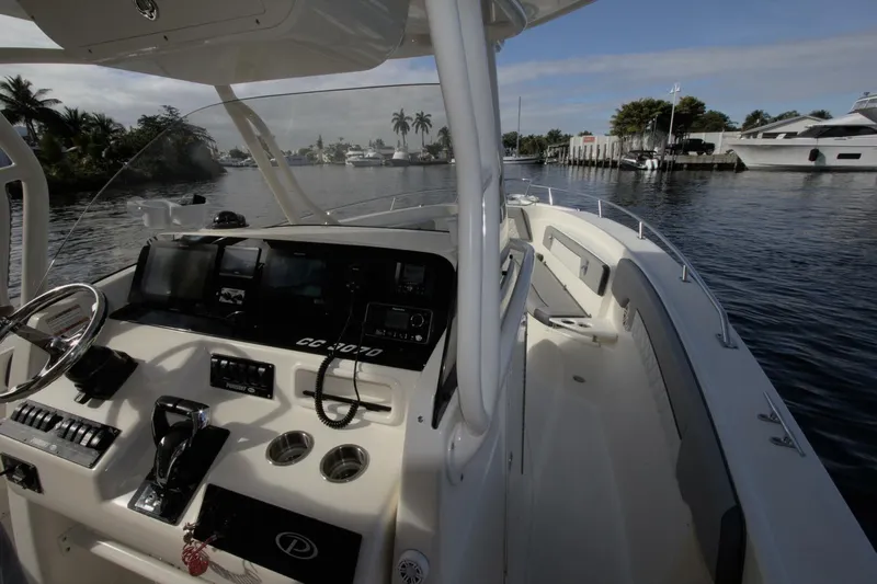  Yacht Photos Pics 2001 Pursuit 3070 Center Console boat on a calm waterway, featuring a sleek helm design.