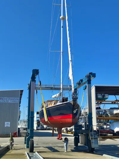 Bella Yacht Photos Pics Tartan 4300 sailboat in a yacht yard, lifted by a crane, clear blue sky.