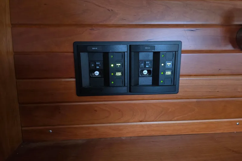 Bella Yacht Photos Pics Electrical panel on Tartan 4300 yacht, 2018 model, mounted on wooden wall.