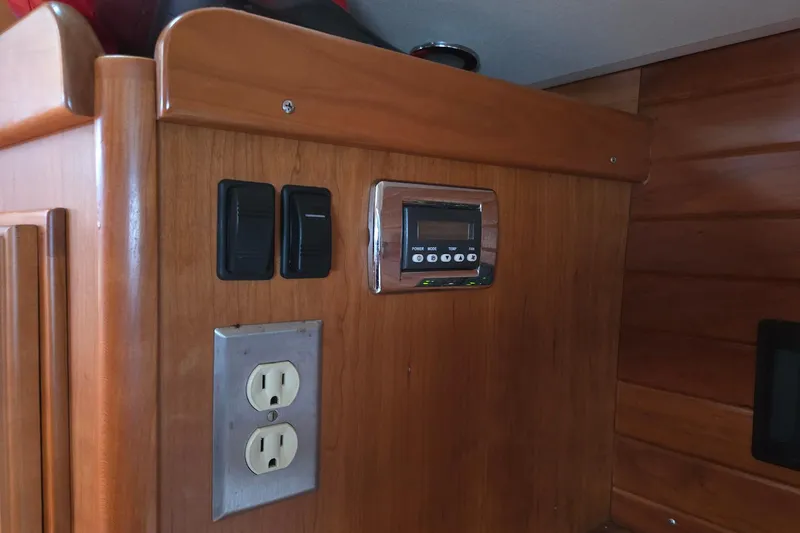 Bella Yacht Photos Pics Wooden interior of a 2018 Tartan 4300 with switches and an electrical outlet.