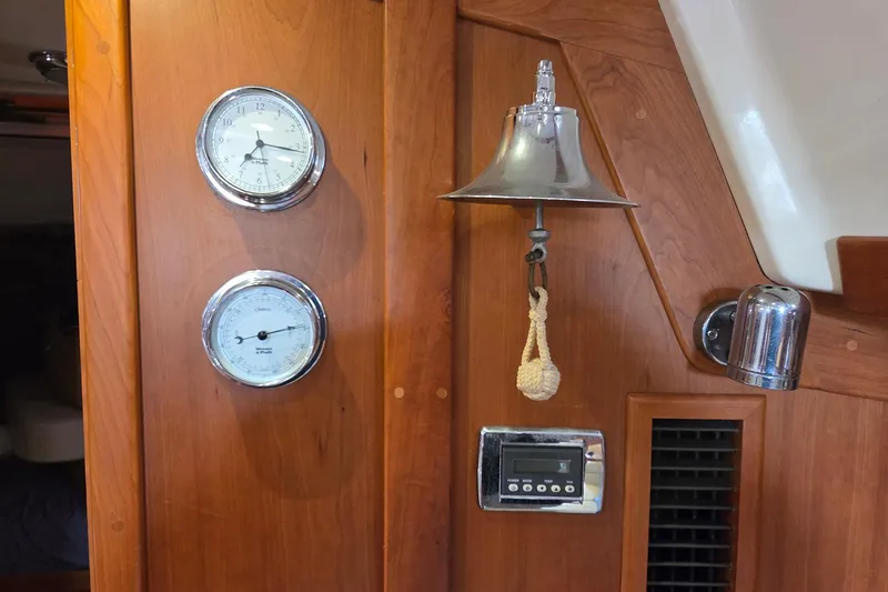 Bella Yacht Photos Pics Interior of 2018 Tartan 4300 yacht with clock, barometer, and bell on wooden panel.