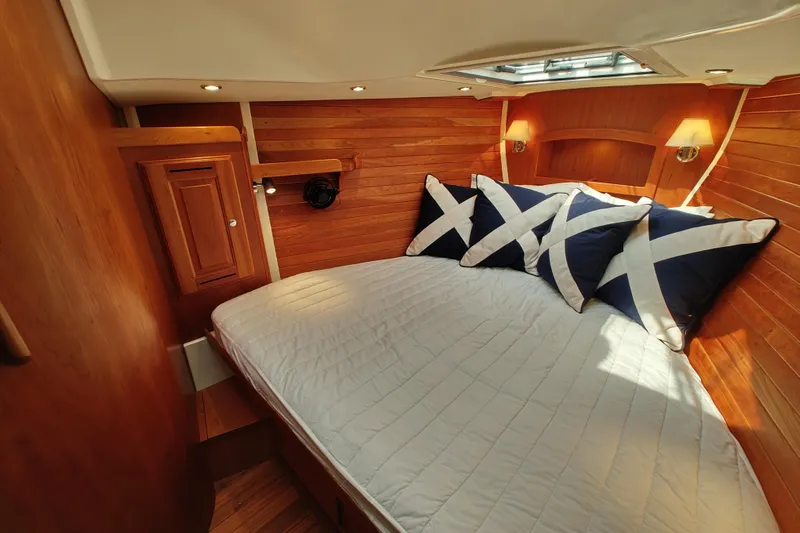 Bella Yacht Photos Pics Cozy cabin interior of 2018 Tartan 4300 yacht with wooden paneling and nautical-themed pillows.
