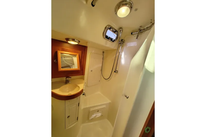 Bella Yacht Photos Pics Compact bathroom in 2018 Tartan 4300 yacht with sink, shower, and mirror.
