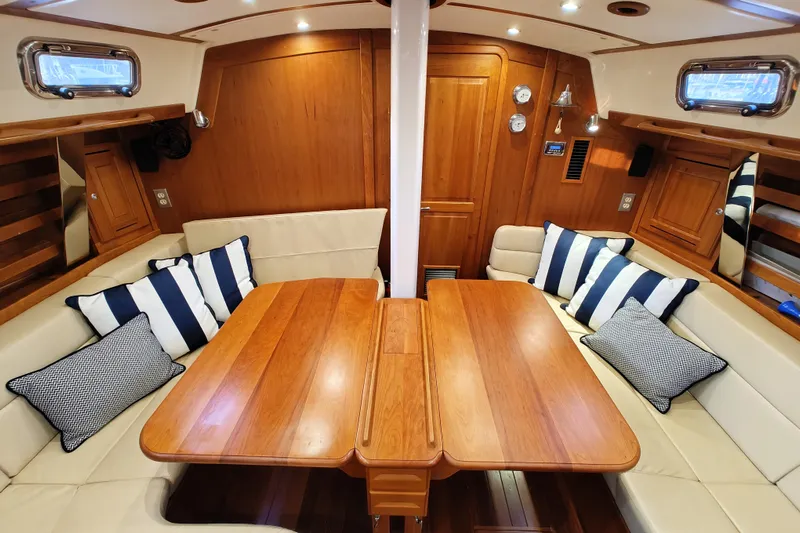 Bella Yacht Photos Pics Luxurious 2018 Tartan 4300 yacht interior with wooden table, striped cushions, and elegant seating.