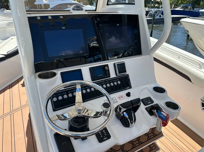  Yacht Photos Pics 2022 Tidewater 280 CC boat dashboard with steering wheel and electronic displays.