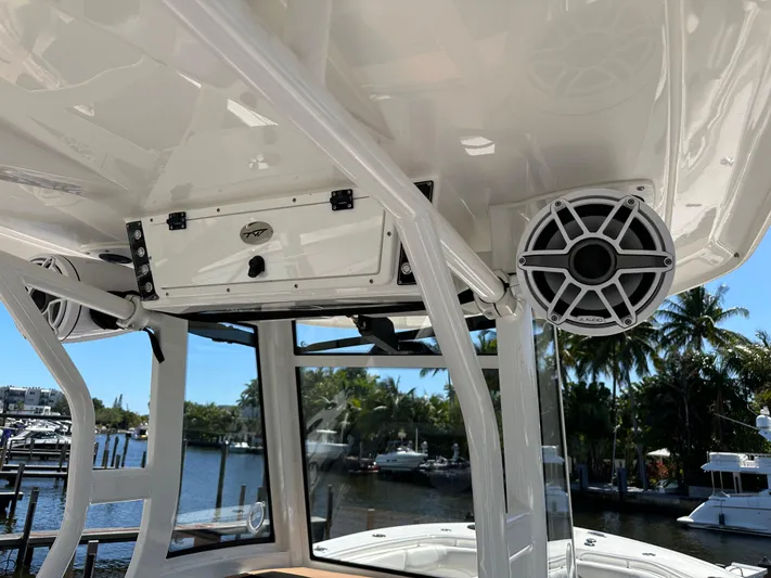  Yacht Photos Pics 2022 Tidewater 280 CC boat interior with speakers and storage, docked by a scenic waterfront.