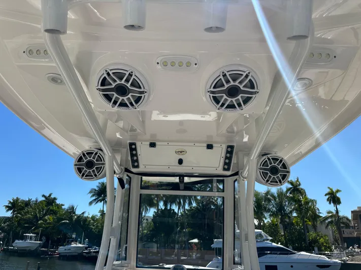  Yacht Photos Pics 2022 Tidewater 280 CC boat speakers and canopy, docked with palm trees in the background.