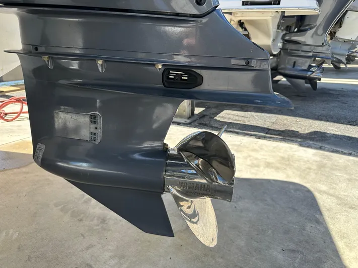  Yacht Photos Pics Outboard motor of a 2022 Tidewater 280 CC boat with a shiny propeller.