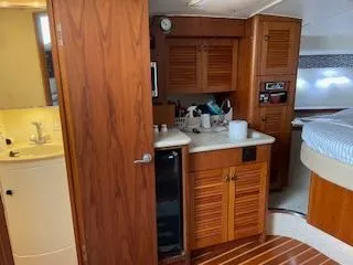 Pathological Yacht Photos Pics Interior of 2000 Pursuit 3400 Express boat with wooden cabinetry and compact amenities.